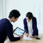 Couple examinant un budget sur une tablette et des documents pour le financement d'électroménager.