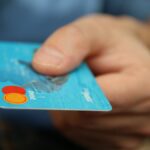 Carnet de budget ouvert avec carte bancaire rangée et contrat de crédit renouvelable inutilisé