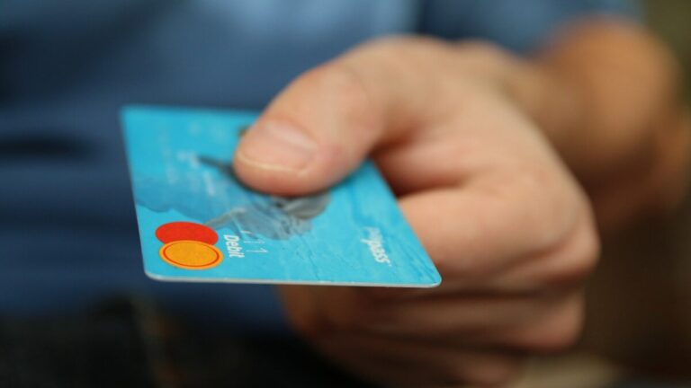 Carnet de budget ouvert avec carte bancaire rangée et contrat de crédit renouvelable inutilisé
