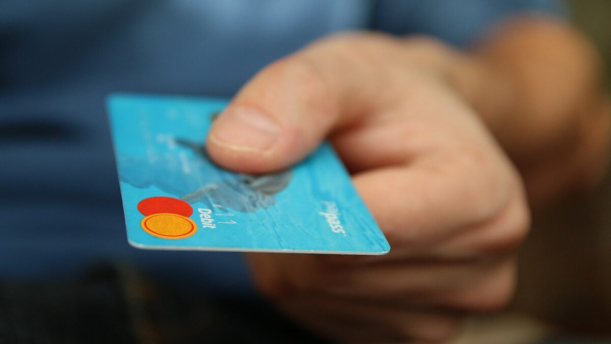 Carnet de budget ouvert avec carte bancaire rangée et contrat de crédit renouvelable inutilisé