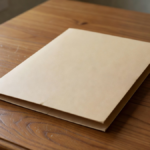 Dossier beige fermé sur un bureau en bois, sans inscription.